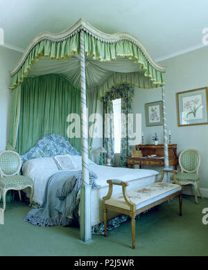 Antico letto a baldacchino con tende di colore verde nel paese camera da letto Foto Stock