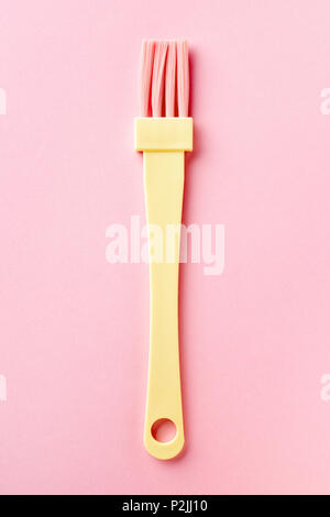 Giallo e rosa spazzola di pasticceria isolato su sfondo rosa, dal di sopra Foto Stock