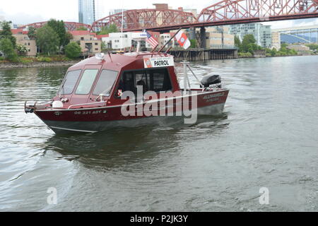 Ron Hilburger, un guardacoste Auxiliarists, e tre compagni di organi ausiliari a bordo della sua barca pattugliare le acque del fiume Willamette a Portland, Ore., 9 giugno 2018. Otto della Guardia costiera navi ausiliarie teamed con active-dovere Coast Guard i membri nel fissaggio della via navigabile durante il Festival di Rose 2018 festeggiamenti. Stati Uniti Coast Guard foto di Sottufficiali di prima classe Levi leggere. Foto Stock