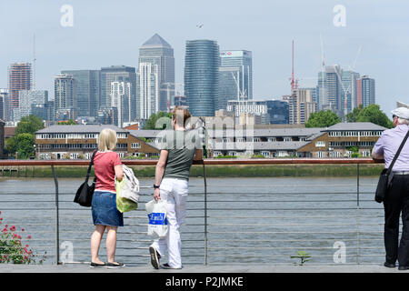 Il quartiere finanziario di grattacieli a Canary Wharf e Isle of Dogs, Londra, Inghilterra, visto attraverso il fiume Tamigi da spettatori curiosi di Greenwich. Foto Stock