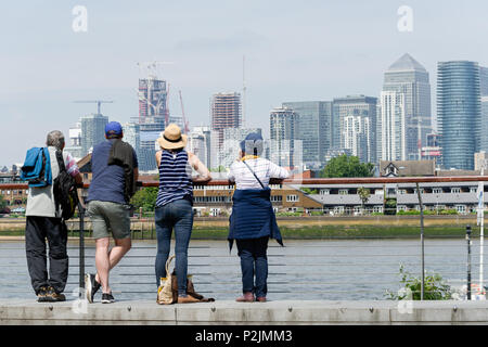 Il quartiere finanziario di grattacieli a Canary Wharf e Isle of Dogs, Londra, Inghilterra, visto attraverso il fiume Tamigi da turisti curiosi di Greenwich. Foto Stock