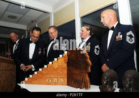 Montana Air National Guard comando stato Chief Master Sgt. Timothy Zumbrun narra come Chief Master Sgt. Osvaldo Mendez accende la prima candela che rappresenta la forza aerea degli Stati Uniti forza arruolato struttura durante il Montana Air National Guard Chief cerimonia di investitura tenutasi presso l'Meadowlark Country Club a Great Falls, Mont., Sett. 30, 2016. Centoventesimo Airlift Wing comando Master Chief Sgt. Steven Lynch assistiti Mendez come direttore di Sgts Master. Teresa Parker e John Weber aspettato per partecipare alla cerimonia. (U.S. Air National Guard foto di Senior Master Sgt. Eric Peterson) Foto Stock