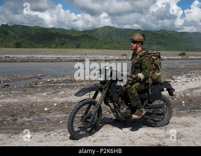 Un U.S. Air Force 320Tattiche speciali Squadron combat controller (TDC) corse dirt bike in Valle Corvo nella provincia di Tarlac, Filippine durante un pistone in Teak 2016 relazioni comunitarie evento con Philippine avanti Air Controller (PFACs) dal 710th Special Operations ala. Cct hanno bisogno di essere competente su una vasta gamma di veicoli, inclusi dirt bike al fine di infiltrarsi in qualunque modo la missione richiede (U.S. Air Force foto da Capt. Jessica Tait) Foto Stock