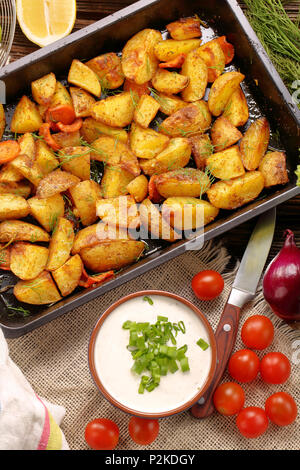 Freschi patate al forno con erbe e dip bianco Foto Stock
