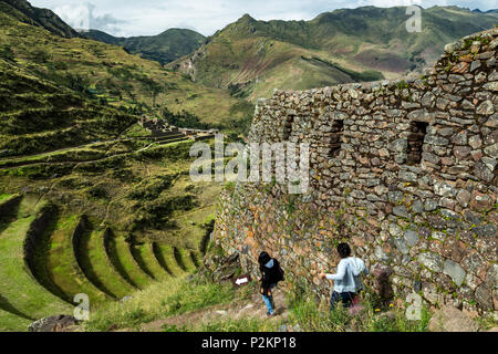 Gli escursionisti sul sentiero, rovine nel settore urbano e terrazzamenti agricoli, Pisac rovine Inca, Pisac, Cusco, Perù Foto Stock