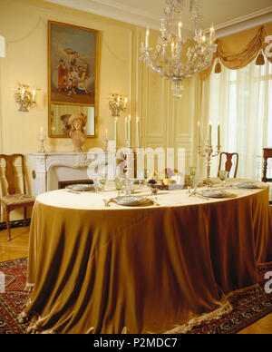 Cristallo di antiquariato lampadario di vetro sopra la tabella con le candele accese e opulento tovaglia in velluto in elegante sala da pranzo Francese Foto Stock