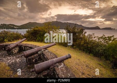 Caraibi, Piccole Antille, Saint Vincent e Grenadine, Bequia Island, cannoni e resti di Hamilton fortilizio militare di fronte a Port Elizabeth, la principessa Margaret Bay al tramonto Foto Stock