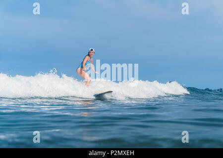 Donna in costume da bagno il surf in oceano Foto Stock