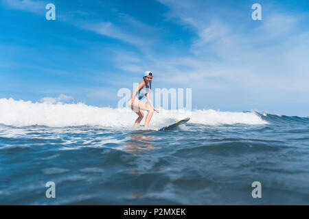 Donna in costume da bagno il surf in oceano Foto Stock