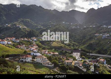 Il Portogallo, l'isola di Madeira, panorama sulla costa nord di La Portela Lookout, il villaggio di Porto da Cruz ai piedi di Eagle Rock (Penha d'Aguia) Foto Stock