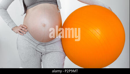 Donna incinta in possesso di una sfera di fitness Foto Stock