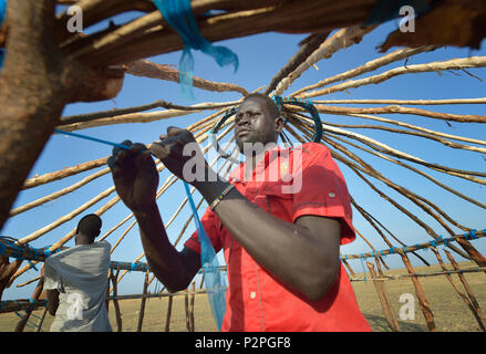 Dau Chol Thuc opere sul tetto della sua nuova casa in Dong Boma, un Dinka villaggio nel sud Sudan è stato Jonglei, il 12 aprile 2017. Foto Stock