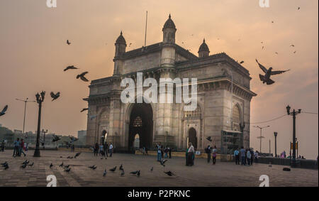 MUMBAI, India - 14 gennaio 2017 - persone non identificate a piedi e piccioni volare intorno al Gateway of India Foto Stock