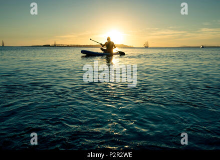 Uomo d'imbarco a pale durante il tramonto sulla spiaggia di Punta del Este, Uruguay. Foto Stock