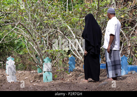 Lhokseumawe, Indonesia. 16 Giugno, 2018. Un giovane musulmano guardando un parenti' grave durante il pellegrinaggio.musulmani visto con i loro parenti' grave durante un pellegrinaggio al cimitero pubblico in città Lhokseumawe. La maggior parte dei musulmani in Aceh già fatto l'ultima tomba pellegrinaggio prima di entrare nel sacro mese del Ramadan e il giorno di Eid al-Fitr, a pregare per le famiglie di coloro che sono morti. Credito: Maskur ha SOPA/images/ZUMA filo/Alamy Live News Foto Stock