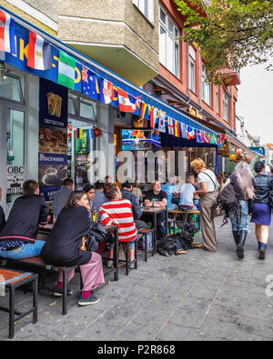 Berlino, Germania. Il 15 giugno, 2018. La Coppa del Mondo di calcio Mania. Tifosi si riuniscono per guardare la Spagna/Portogallo gioco attorno a Rosenthaler Platz dove le bandiere nazionali al flutter in ogni bar, cafe & restaurant presenta una schermata televisiva di credito: Eden Breitz/Alamy Live News Foto Stock