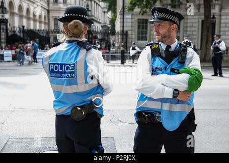 Londra, Regno Unito. 16 Giugno, 2018. Un ufficio di collegamento della polizia in Whitehall indossando una sciarpa verde in solidarietà con la comunità Grenfell alla giustizia per Grenfell solidarietà marzo in due giorni dopo il primo anniversario della torre Grenfell fuoco durante la quale 72 morti e oltre 70 feriti. Foto Stock