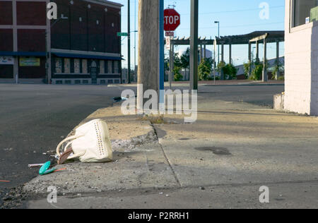 Furto di borsa aperta rotto su un marciapiede con possedimenti sparsi in strada in una città deserta intersezione Foto Stock