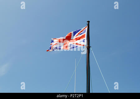 Union Jack flag battenti in la brezza contro un cielo blu sullo sfondo. Foto Stock