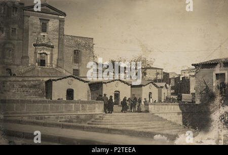 . Italiano: Caltanissetta - Chiesa dedicata alla Madonna della Grazia, costruita nel XVII sec. (1620) a seguito di un fatto ritenuto miracoloso, vicino alla cappelletta, eretta sul luogo del miracolo, accanto alla torre dei Piazzi. Nell'immagine (foto Telaro 1930) si vedono la chiesa con le scala a doppia rampa, il bastione del muro di contenimento della strada, oggi via M. Calafato, si vede anche il parapetto in muratura sul bastione demolito per allargare il marciapiede e sostituito da ringhiera in ferro; si vedono anche, addossati al muro, i padiglioni del mercato generale realizzati sullo Foto Stock