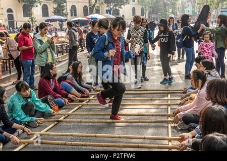 Pubblico di godere di giochi nel traffico zona franca Hanoi Vietnam a fine settimana. Foto Stock