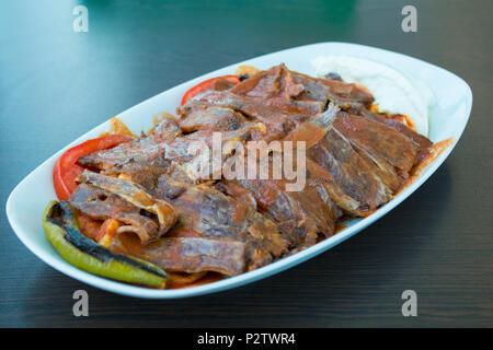 Bagno turco iskender kebab con decorazione su una superficie di legno al ristorante Foto Stock