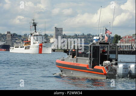 L'equipaggio del guardacoste attivo, un 210-piede di medie Endurance homeported Cutter in Port Angeles, nello Stato di Washington, si prepara a moor dopo che partecipano al Seafair Parade di navi come un 29-piede Boat-Small risposta equipaggio dalla stazione della Guardia Costiera Seattle fornisce una scorta di sicurezza nella Baia di Elliott, 2 agosto 2016. Coast Guard cutters sono state partecipando alla Seafair annuale parata di navi sin dal suo inizio nel 1950. Stati Uniti Coast Guard foto di Sottufficiali di terza classe Amanda Norcross. Foto Stock