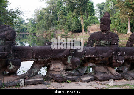 Angkor Cambogia, statua di custode Asura sulla strada rialzata che attraversa il fossato all'entrata ovest al XII secolo Preah Khan temple Foto Stock