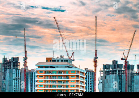 Bird vista sul paesaggio urbano e la costruzione sito incluse più gru lavorando su un complesso di edifici, con sole e nuvole al mattino.spazio copia.B Foto Stock
