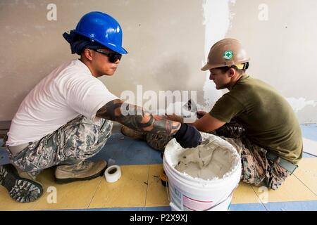 160804-N-CV785-053 KUANTAN, Malesia (Agosto 8, 2016) DEGLI STATI UNITI Air Force Tech. Sgt. Il Ciad Collado (sinistra) e U.S. Marine Corps Cpl. Prelievo di Reed di riempire gli spazi di appena montato teli di cemento in un'aula, assistendo con rinnovi a Tabika Kemas Felda Bukit Kindergarten, come parte del partenariato Pacifico 2016. Stati Uniti Navy Seabees e malese esercito engineering e il personale di trasporto rinnovato l'asilo durante il periodo di 2-13 agosto, l'installazione di pareti, soffitti e abbellire l'ambiente per gli studenti. Questa è la prima volta Pacific Partnership ha visitato Malesia. Durante la missione stop Foto Stock