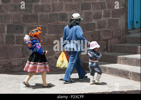 Famiglia Peruviana a piedi nella città di Cusco Peru, Sud America. È una ragazza vestita in un colorato tradizionale costume peruviano. Foto Stock