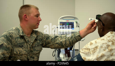 Stati Uniti Air Force Senior Airman Zachary Cisar, 934th Istituto di medicina aeronautica Staging Squadron, controlla la temperatura di un veterano durante il 2016 veterani Stand giù a Fort Snelling, Minn., 2 agosto 2016. I veterani Stand all evento offre le forniture e i servizi come la sanità screening, informazioni legali, le segnalazioni di alloggiamento e di occupazione per i veterani senzatetto. (U.S. Air National Guard foto di Tech. Sgt. Amy M. Lovgren/rilasciato) Foto Stock