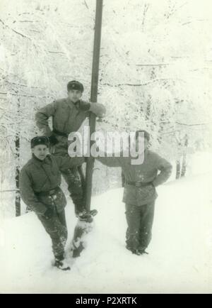 La REPUBBLICA SOCIALISTA CECOSLOVACCA - circa settanta: Retro mostra fotografica di giovani uomini (soldati) durante il periodo invernale. I soldati pongono all'aperto (snowy meteo). Fotografia vintage. Foto Stock