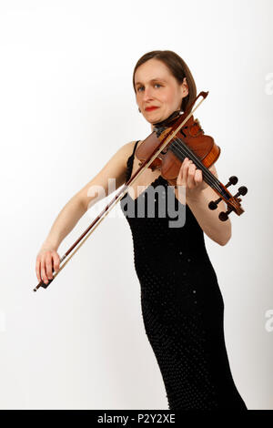 Giovane donna in un concerto di nero vestito a suonare il violino Foto Stock