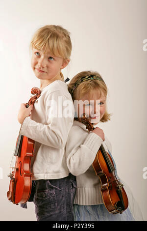 Angelo e imp, due ragazze tenendo i loro violini Foto Stock