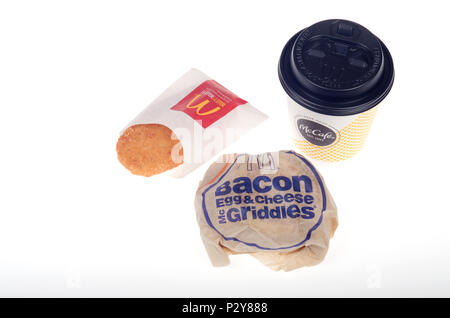 McDonald's Colazione di bacon, uova e formaggio McGriddle con hash brown tortino di patate e la tazza di caffè su sfondo bianco Foto Stock