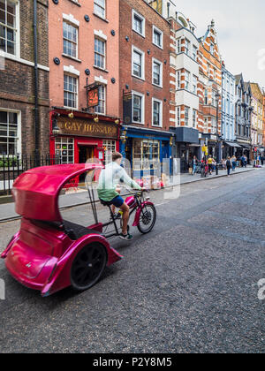 London cycle rickshaw o cicli di Pedicab passato il Gay Hussar ristorante in Greco Street in Soho il quartiere del divertimento Foto Stock