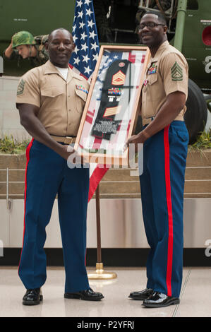 Stati Uniti Marine Corps Gunnery Sgt. Bobby Stafford riceve un regalo durante il suo pensionamento cerimonia presso il Museo Nazionale del Marine Corps, Triangolo, Virginia, e il Agosto 5, 2016. Stafford si è ritirato dopo aver servito onorevolmente per 17 anni. (U.S. Marine Corps photo by Lance Cpl. Yasmin D. Perez/RILASCIATO). Foto Stock