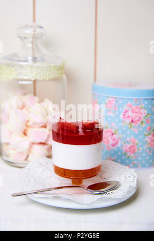 Fragola dessert su un piattino con pizzo vicino a una possibile con marshmallows. Foto Stock