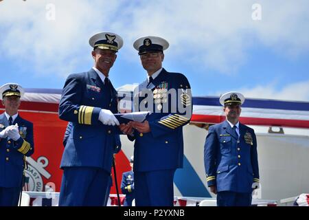 Area del Pacifico il comando Master Chief Petty Officer Mark Pearson presenta Vice Adm. Charles W. Ray una bandiera che è stata abbassata dalla Guardacoste Waesche durante il Coast Guard Area pacifico cambio di comando cerimonia, lunedì, 15 agosto 2016 presso la Guardia Costiera Alameda di base in California. Area del Pacifico è il Coast Guard regionale dell'elemento di comando e fornitore di forze per la sicurezza marittima, la sicurezza e la gestione amministrativa del Pacifico. Stati Uniti Coast Guard foto di Sottufficiali di terza classe Loumania Stewart Foto Stock