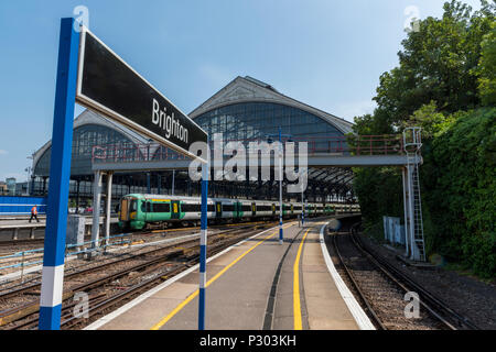 La principale stazione ferroviaria a Brighton in east sussex. Le piattaforme lungo e una grande tettoia di vetro a Brighton mainline rail station. treni pendolari. Foto Stock