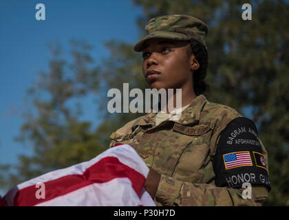 Airman 1. Classe Taylor Davis, 455th Air Expeditionary ala guardia d'onore gli stati, di pieghe di un flag durante una cerimonia di ritiro, Bagram Airfield, Afghanistan, 15 agosto 2016. Libertà di sentinella, il follow-on di Enduring Freedom, è il costante sforzo degli Stati Uniti per treno, consigliare e assistere le forze di sicurezza afgane nonché condurre la lotta contro il terrorismo le operazioni in Afghanistan. (U.S. Air Force foto di Senior Airman Justyn M. Freeman) Foto Stock