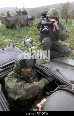 Air Force (USAF) Tecnico sergente (TSGT) James Monaco, un videografo assegnato al trentesimo Communications Squadron (CS), utilizza una videocamera digitale al documento esercito portoghese soldati a bordo un Chaimite V-200 corazzato Trasporto di personale, sul Glamoc live-Incendio campo, pur partecipando in esercizio risolvere liberiana, a Camp Butmir, in Bosnia ed Erzegovina. Foto Stock