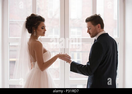 I giovani coniugi Holding Hands, cerimonia giorno di nozze Foto Stock