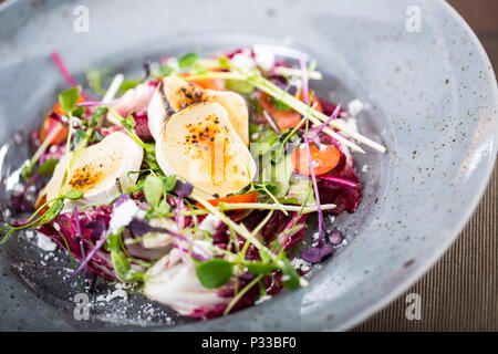 Insalata di verdure con formaggio di capra e decorazione di erbe. Foto Stock