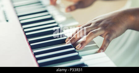 In primo piano una donna nera giocando le mani sul pianoforte. Foto Stock