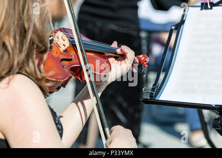 Donna suona il violino durante il concerto di musica classica su strada Foto Stock