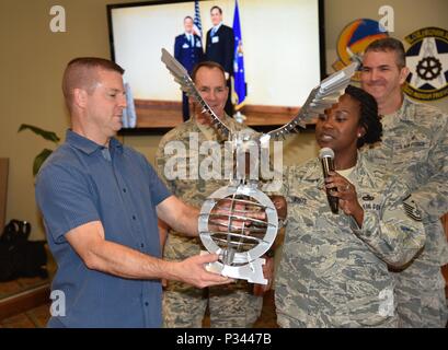 A nome dell'ala 403prima sergenti consiglio, Master Sgt. Demetrice bianco, 403disponibilità logistica squadrone primo sergente, presenta Col. Frank L. Amodeo, 403Wing Commander con un aquila presso il suo addio reception, il 6 agosto 2016. Amodeo è programmato per prendere il comando della 927th Air Refuelling Wing, MacDill Air Force Base in Florida, Sett. 11, 2016. (U.S. Air Force foto/Il Mag. Marnee A.C. Losurdo) Foto Stock