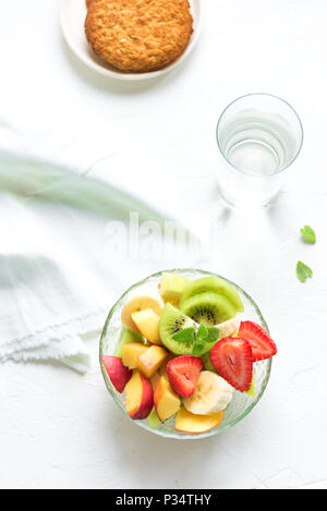 Insalata di frutta in vaso per una sana colazione o uno spuntino. La dieta vegetariano crudo alimentare fitness e il concetto di stile di vita, sfondo bianco con copia spazio. Foto Stock