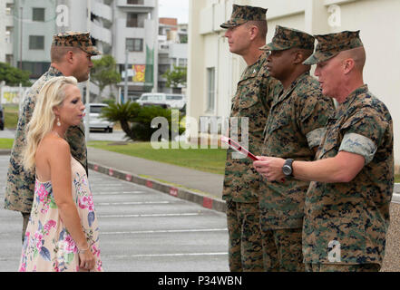 Sgt. Il Mag. James N. Calbough, sergente maggiore del 3° Marine Logistics Group, legge il Navy e Marine Corps encomio medaglia citazione durante una cerimonia in onore di Gunnery Sgt. Scott M. Dahn e sua moglie, aprile B. Dahn, Giugno 12, 2018 a Camp Kinser, Okinawa, in Giappone. Il giovane è stato premiato da Col. Ronald C. Braney, il comandante della terza MLG, per le loro azioni eroiche al punto Maeda, Okinawa, in Giappone, 20 maggio 2018. Un turista da Hong Kong, Ching-Yi Sze, è stato panico subacquea, aveva rimosso il suo regolatore aria e stava cominciando a prendere in acqua quando Dahn vennero in suo aiuto. Egli ha fornito la sua con ox Foto Stock